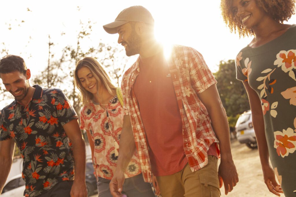 Weird Fish brand image featuring a group of people in casual clothes smiling as they walk in the sunshine.